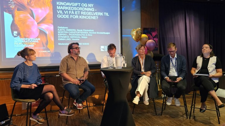 foto. seks personer sitter i panelsamtale under skjerm med påskriften Kinoavgift og ny markedsordning - vil vi få et regelverk til gode for kinoene?